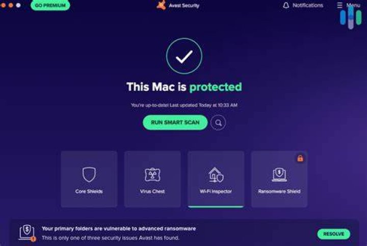A laptop screen showing a shield icon protecting against virus and malware attacks